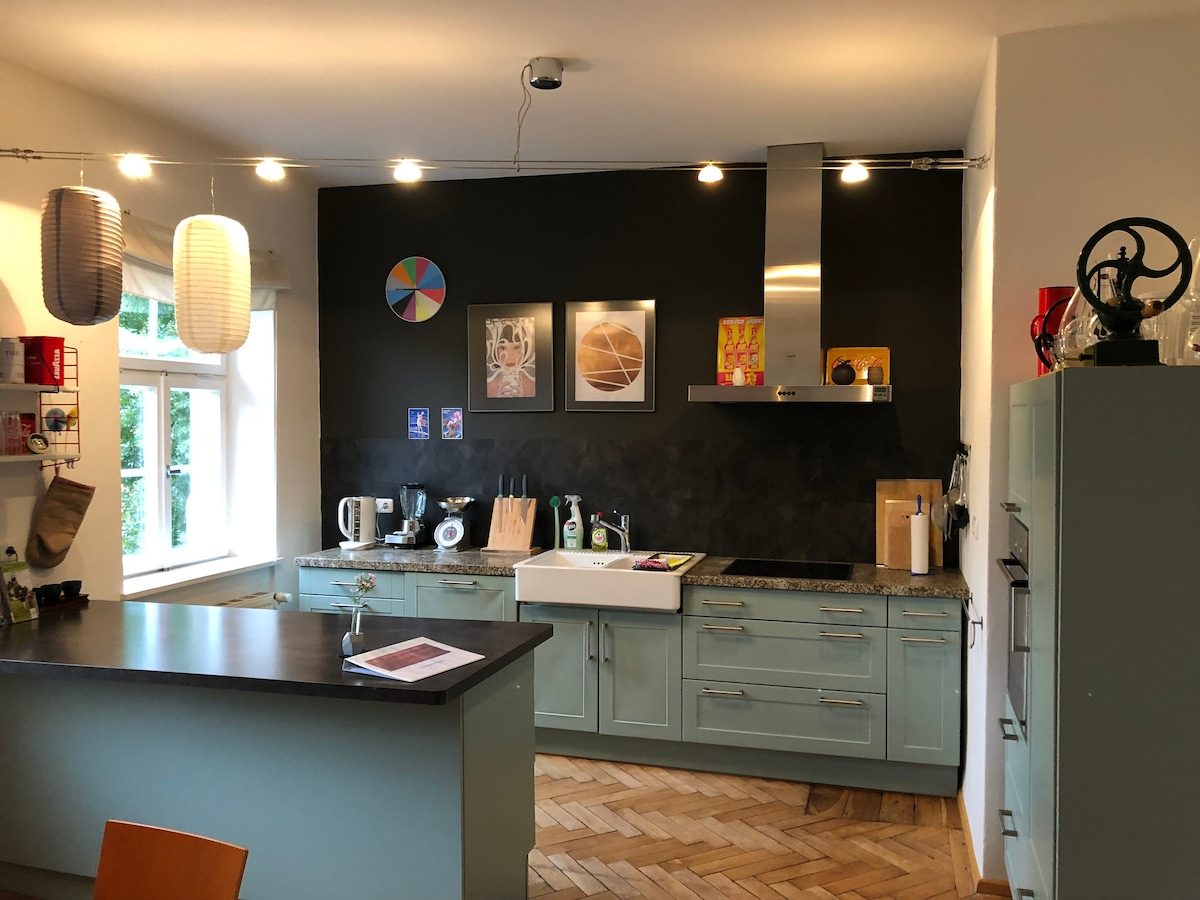 Hochwertig ausgestattete Küche der Wohnung mit salbeigrünen Fronten und Lichterkette.