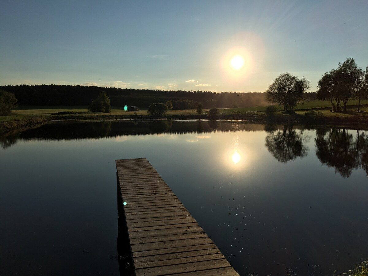 Holzsteg am Badeweiher im ersten Morgenlicht.