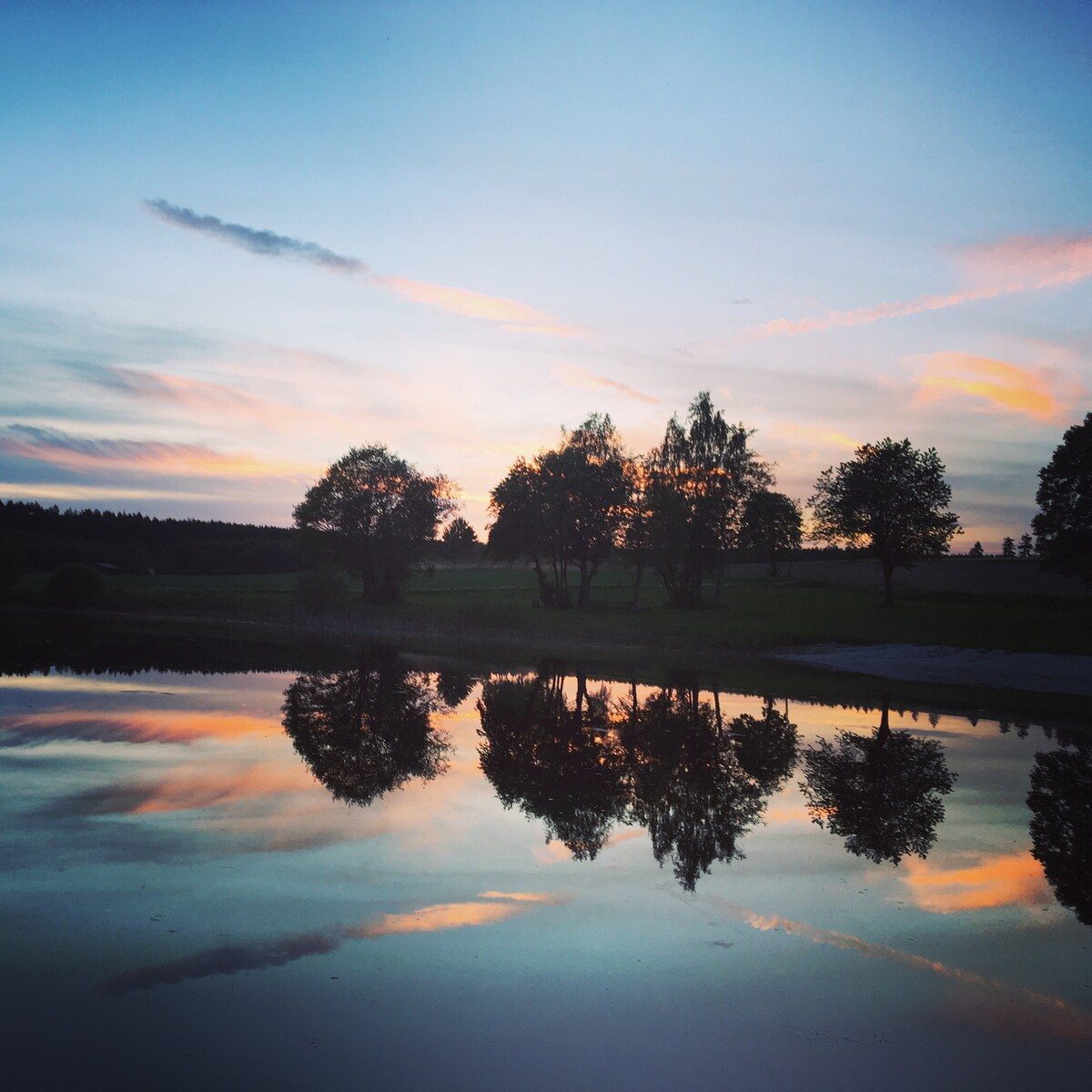 Badeweiher in der Abenddämmerung mit rosa Himmel.